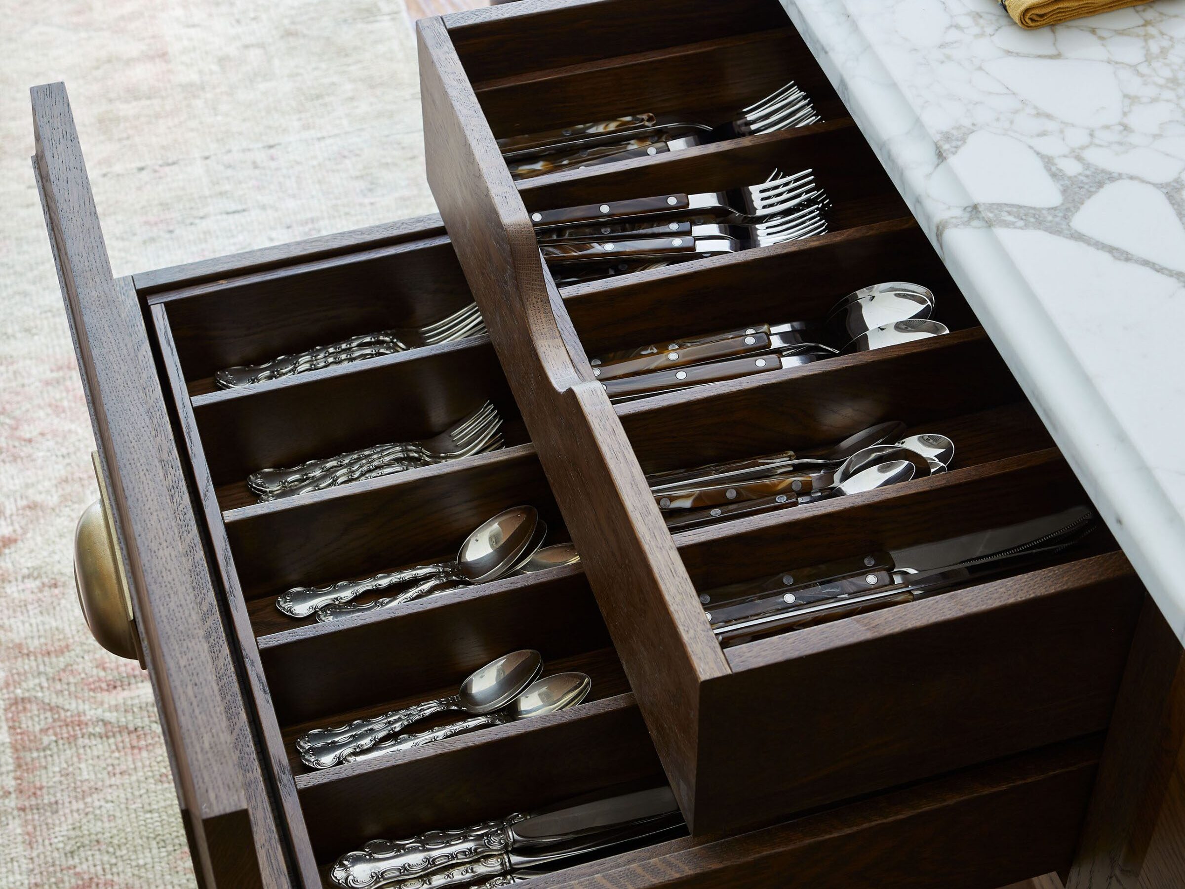 Custom wood kitchen drawer with built-in flatware organizers and tailored utensil storage by Unique Kitchens & Baths™.