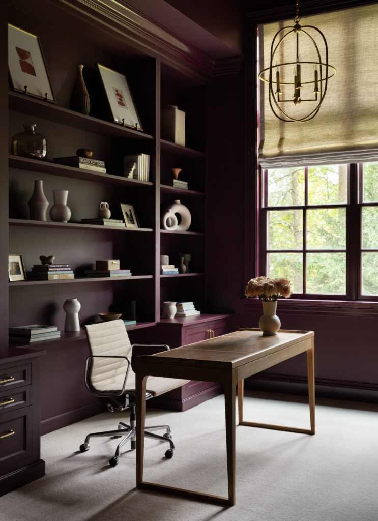 Custom burgundy home office with floor-to-ceiling built-in cabinetry, integrated desk, open shelving, and architectural millwork by Unique Kitchens & Baths™.